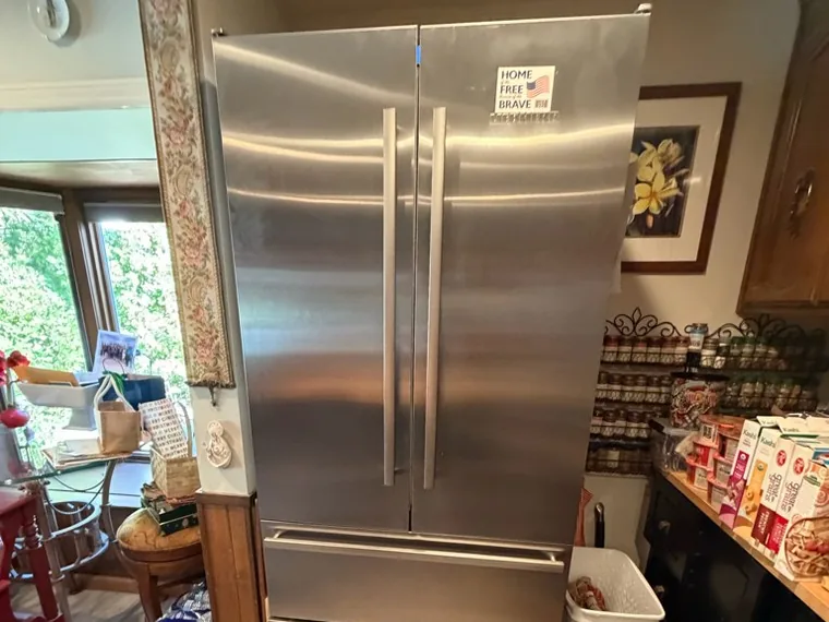 Tall stainless double-door refrigerator with freezer drawers, of the kind Sunny installs and services