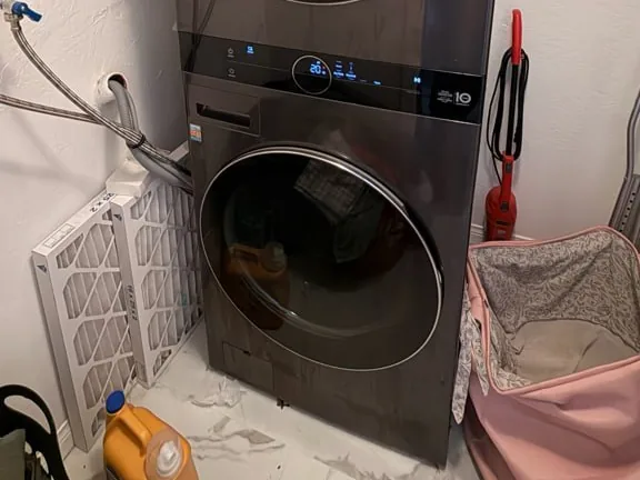 Front-load washer part way through a cycle, drum loaded, of the kind Sunny services