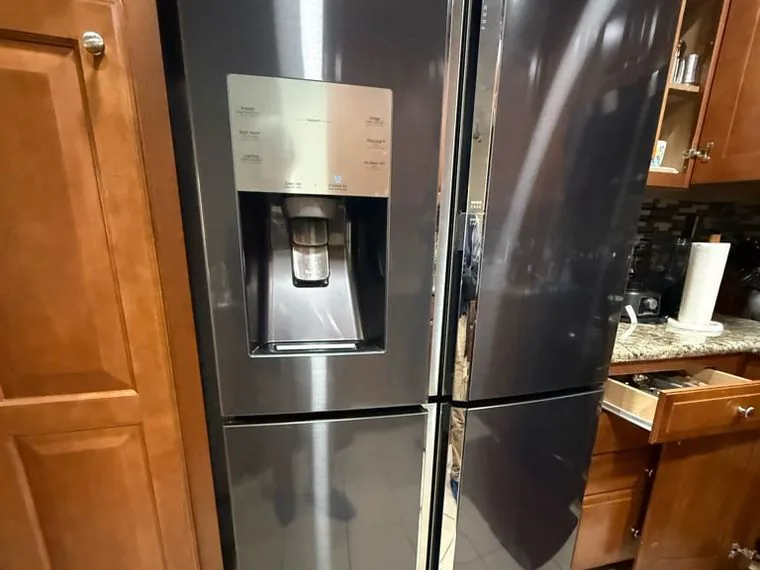 Black stainless LG french-door refrigerator with a water and ice dispenser, in a Bay Area kitchen Sunny works in